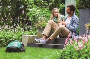 Vater sitzt mit Tochter im Garten